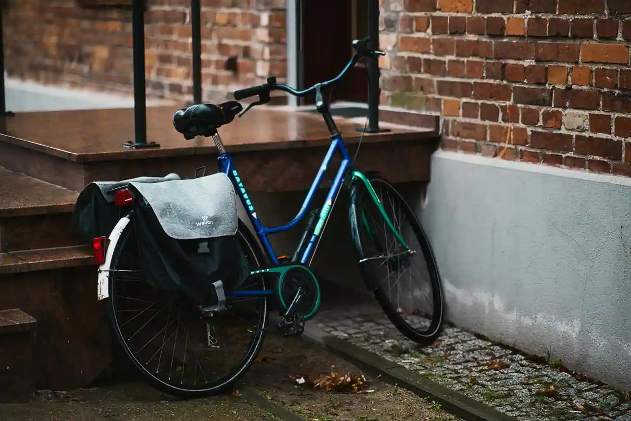Vélo de ville équipé d'une sacoche, d'un éclairage et d'un antivol stationné dans une rue