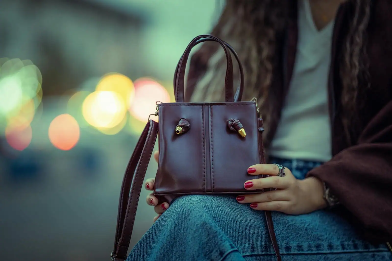 Sac à main de marque posé sur une surface claire, anses et quincaillerie métallique bien visibles