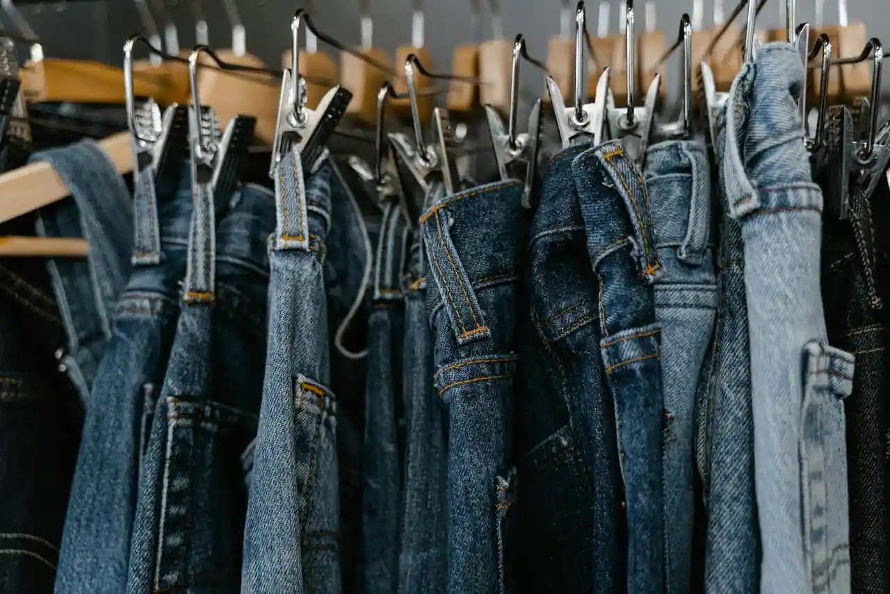 Sélection de jeans en denim de différentes coupes présentés sur des cintres en boutique