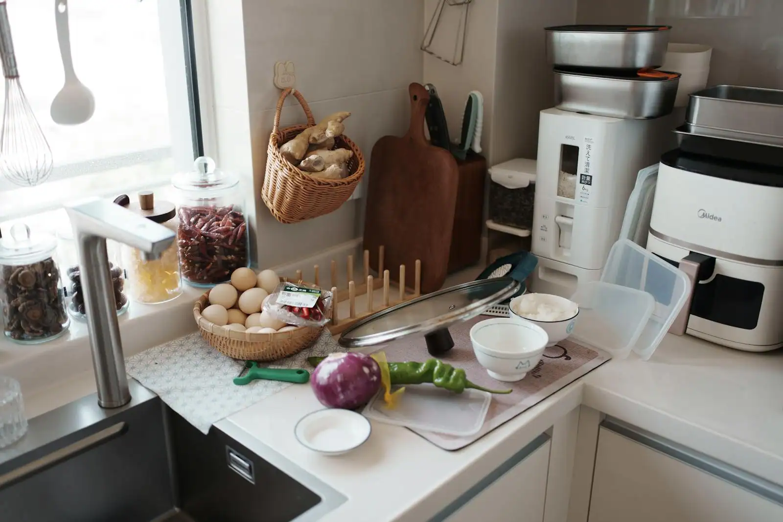 Friteuse sans huile ouverte sur un plan de travail avec quelques accessoires de cuisson
