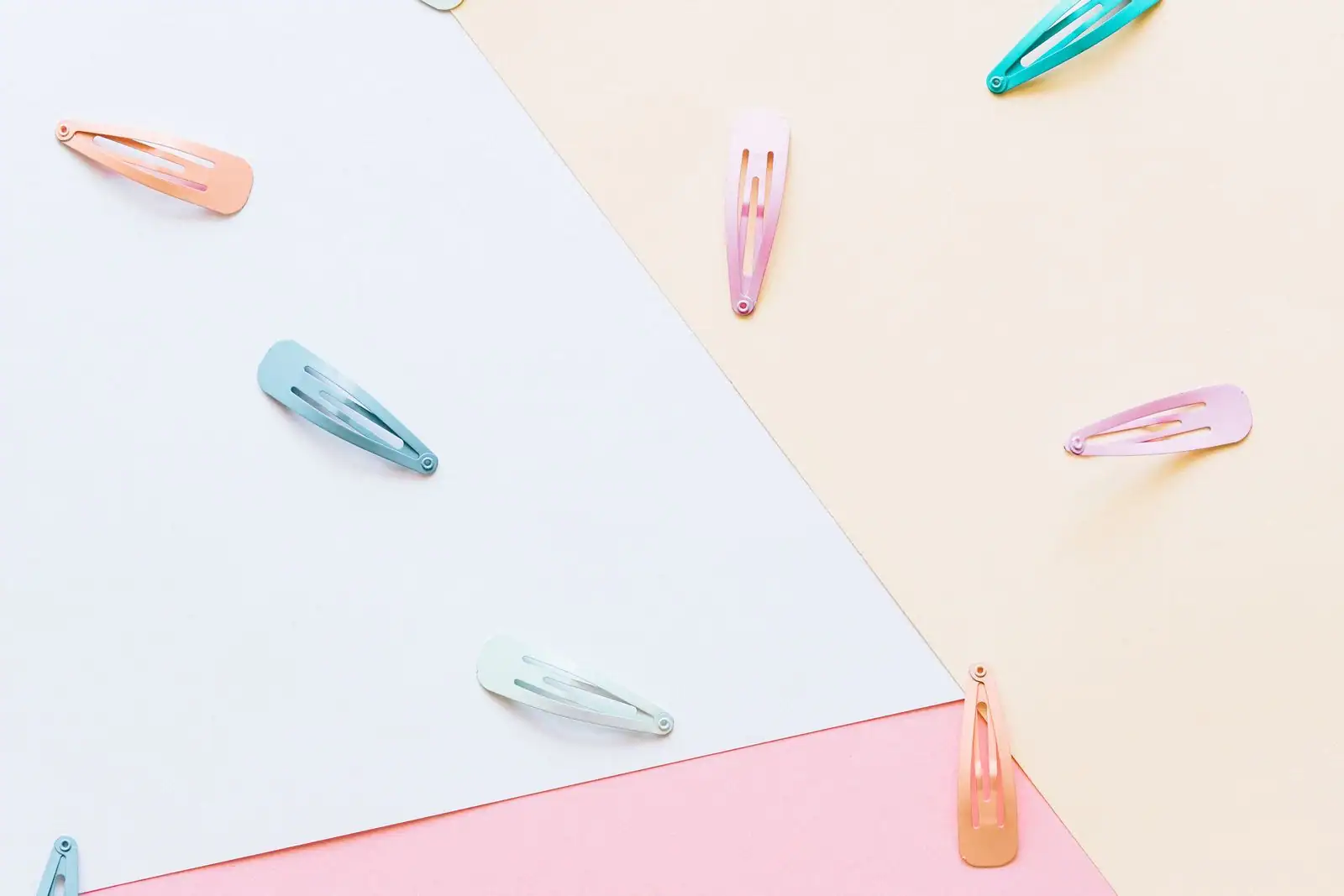 Assortiment d'accessoires cheveux posés sur une surface claire : chouchous en tissu, pinces et barrettes