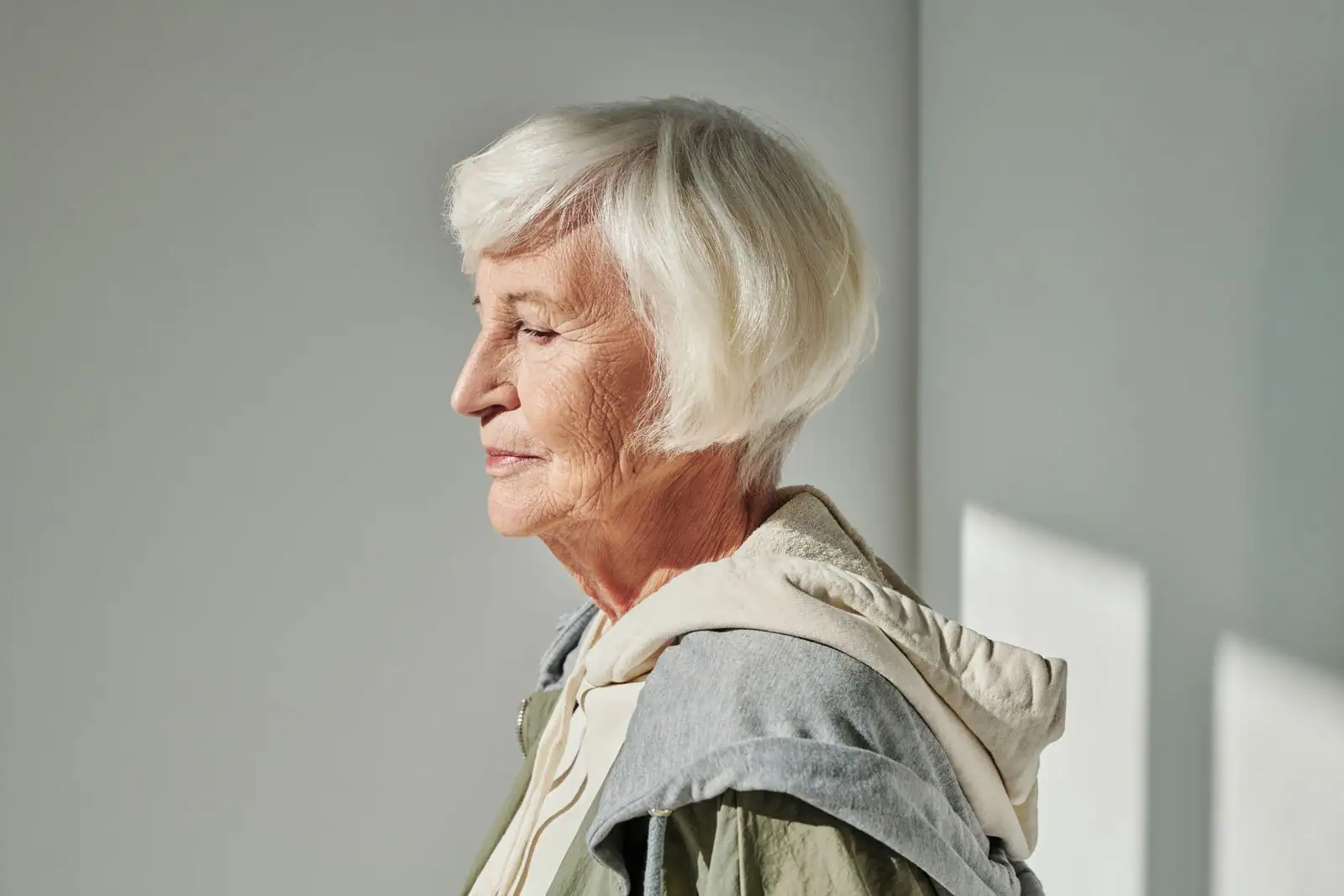 Portrait d'une femme aux cheveux gris argentés naturels, coiffure soignée et lumière douce