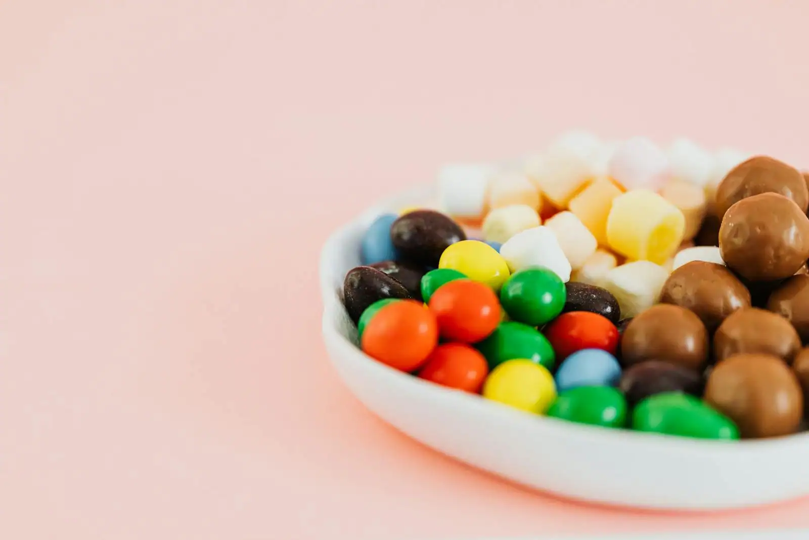 Dragées pastel disposées dans un ballotin pour un baptême