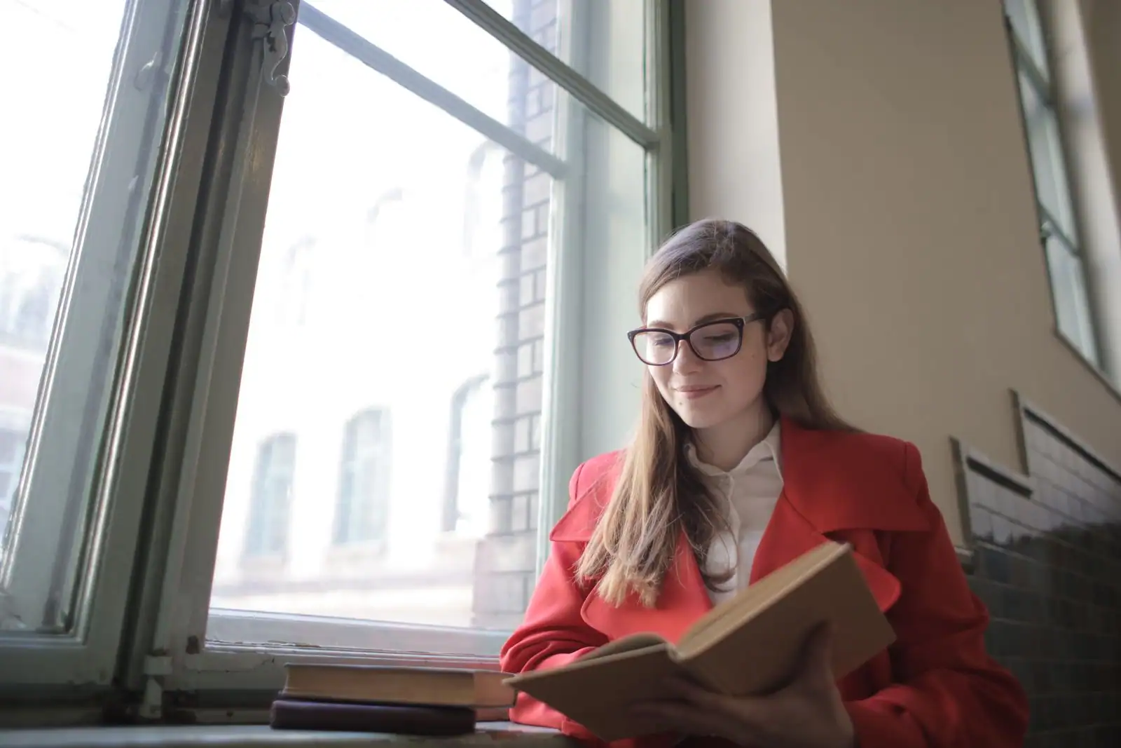 Femme lisant un livre dans une lumière douce, moment calme à la maison