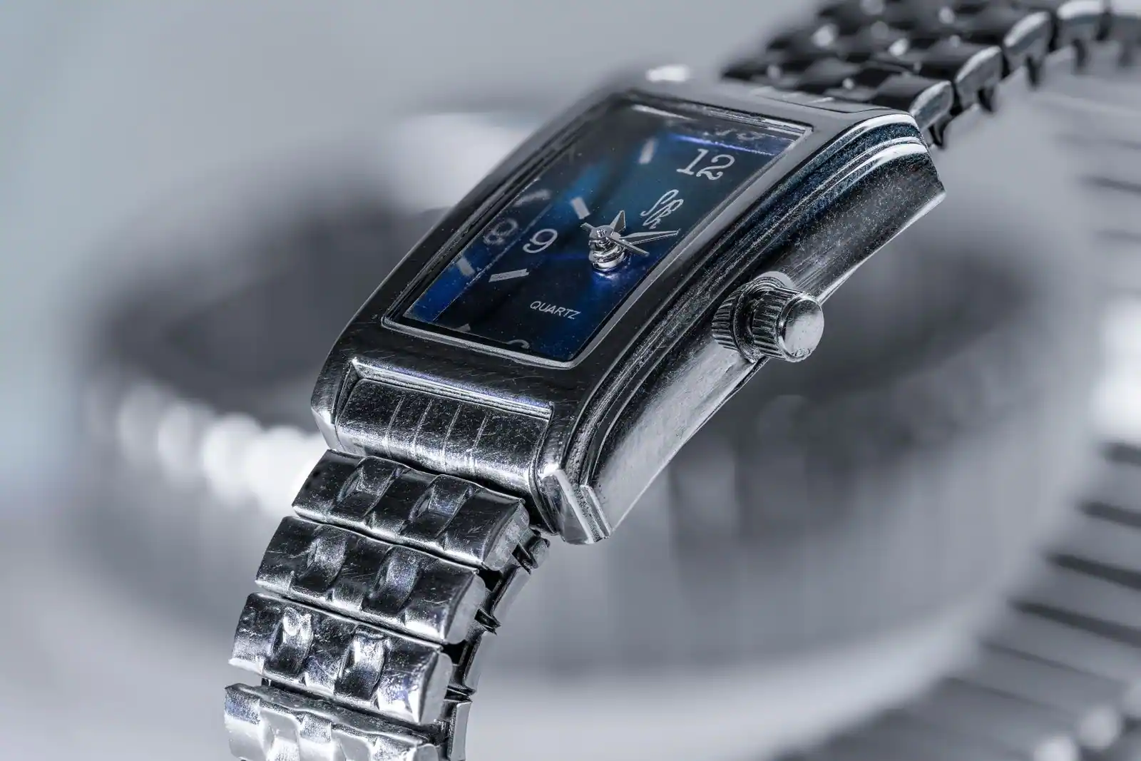 Montre femme au bracelet argenté portée au poignet, cadran clair