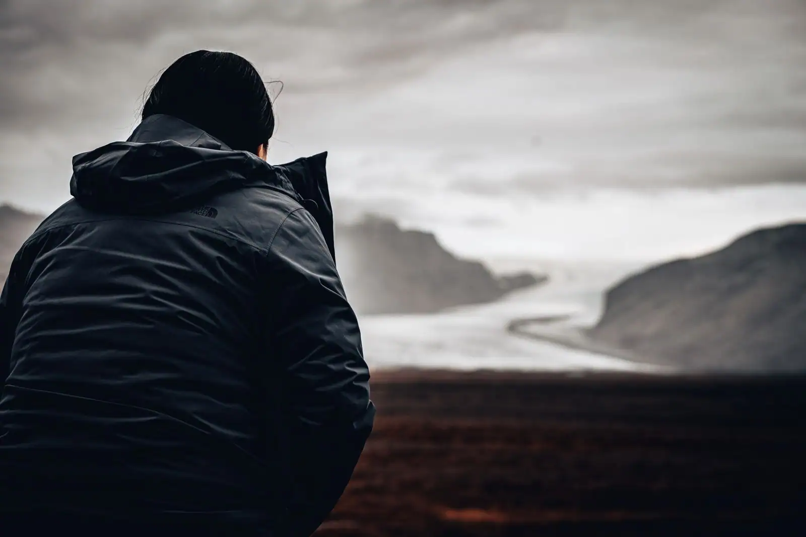 Voyageur de dos face à un vaste paysage, évoquant le métier de globe-trotter