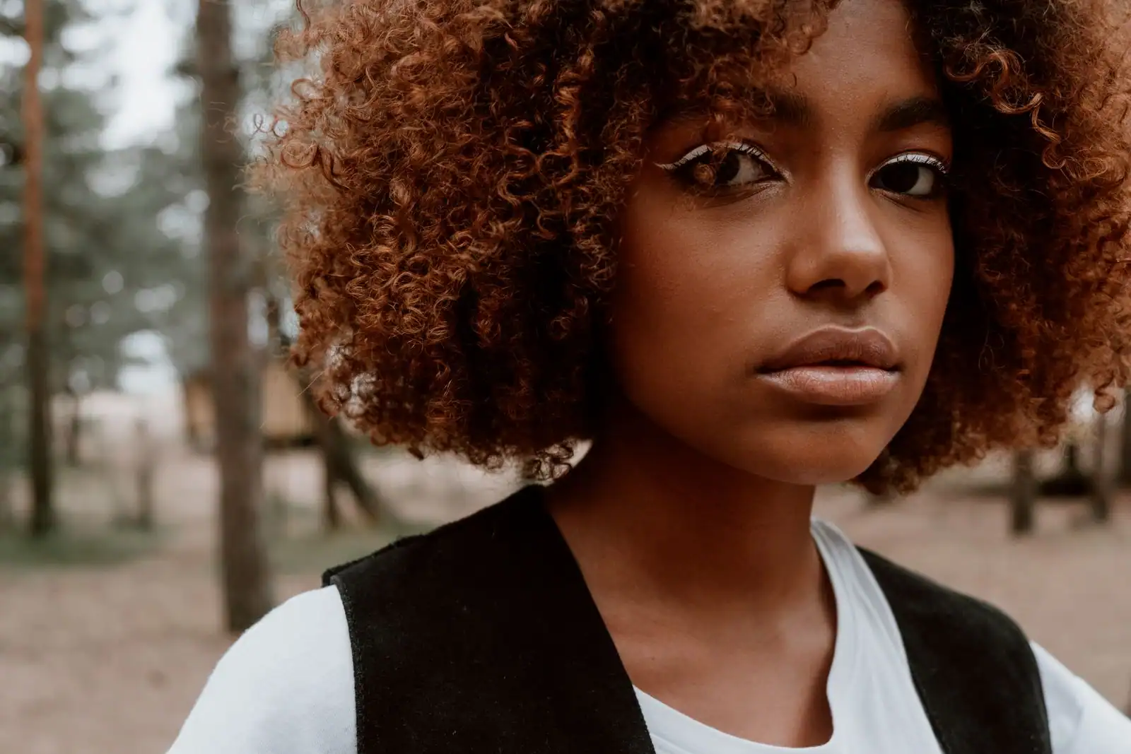 Femme aux cheveux crépus définis et hydratés, gros plan sur la texture des boucles serrées