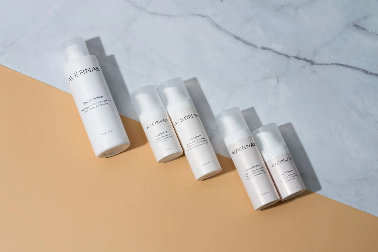 Plusieurs produits de soin du visage alignés sur un plan en marbre clair