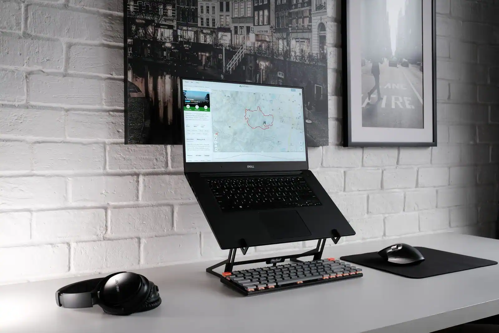 Ordinateur portable sur un support, avec clavier externe, souris et casque sur un bureau