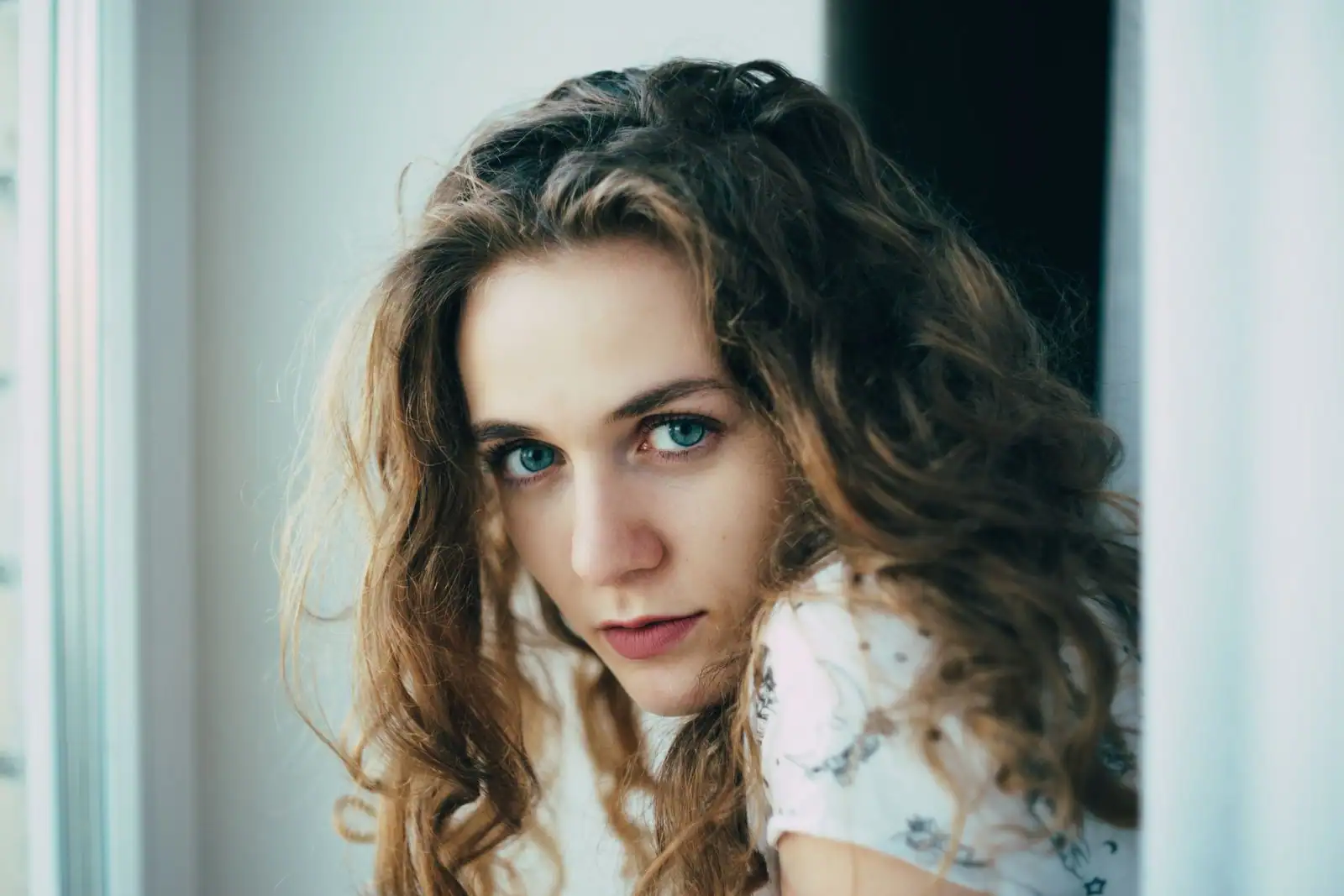 Femme aux longs cheveux châtains ondulés et volumineux, vague naturelle.