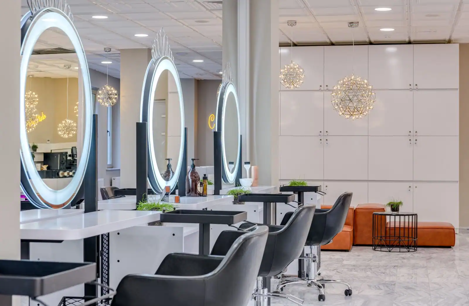 Photo d'illustration : intérieur de salon de coiffure, fauteuils alignés devant des miroirs lumineux