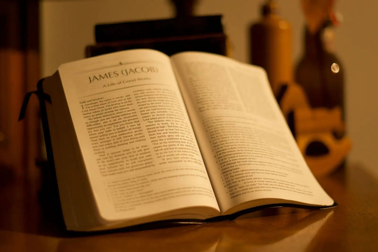 Bible ouverte posée sur une table en bois, éclairée par une lumière douce