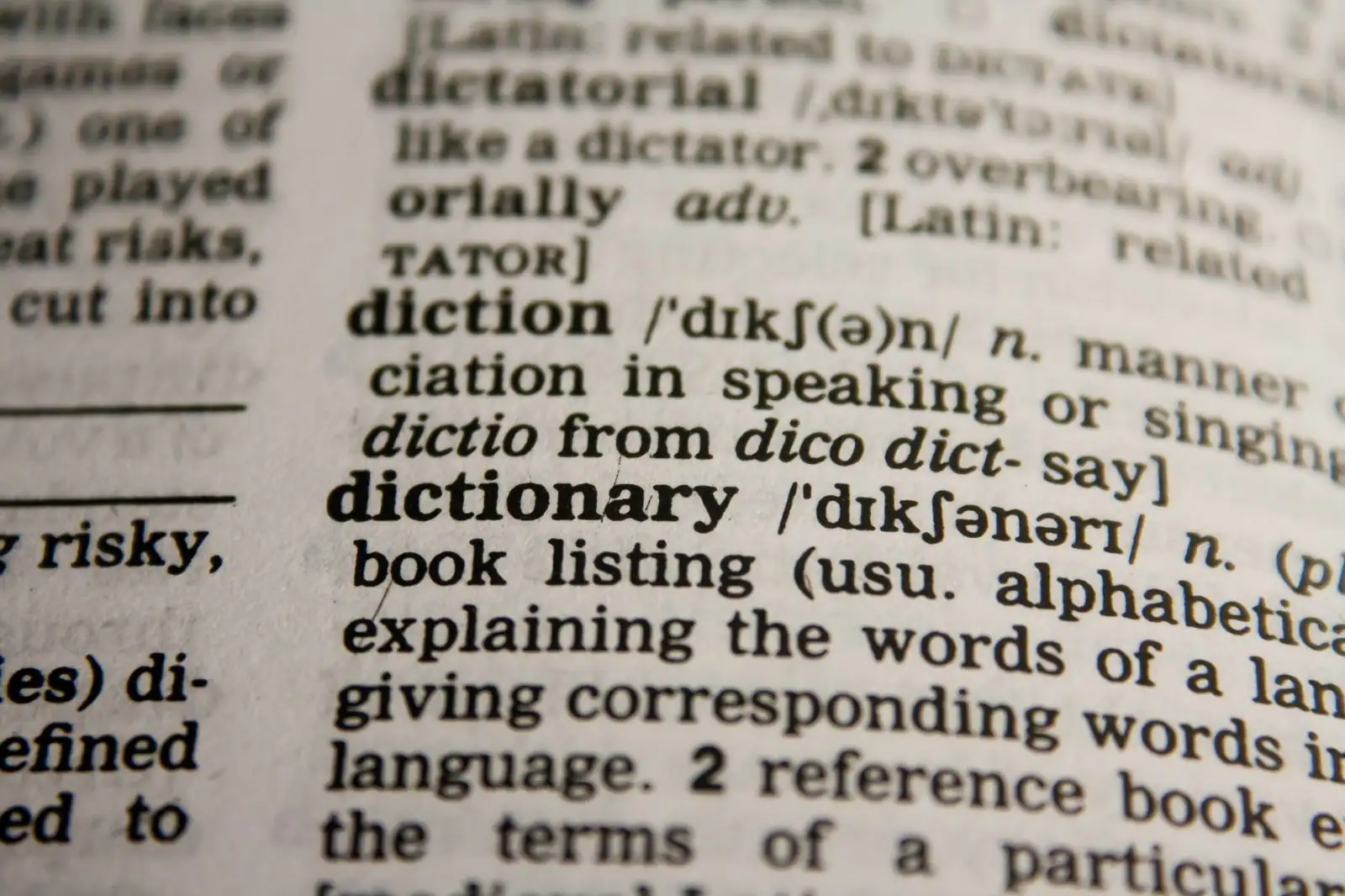 Page de dictionnaire anglais en gros plan, entrée « dictionary » et sa transcription phonétique