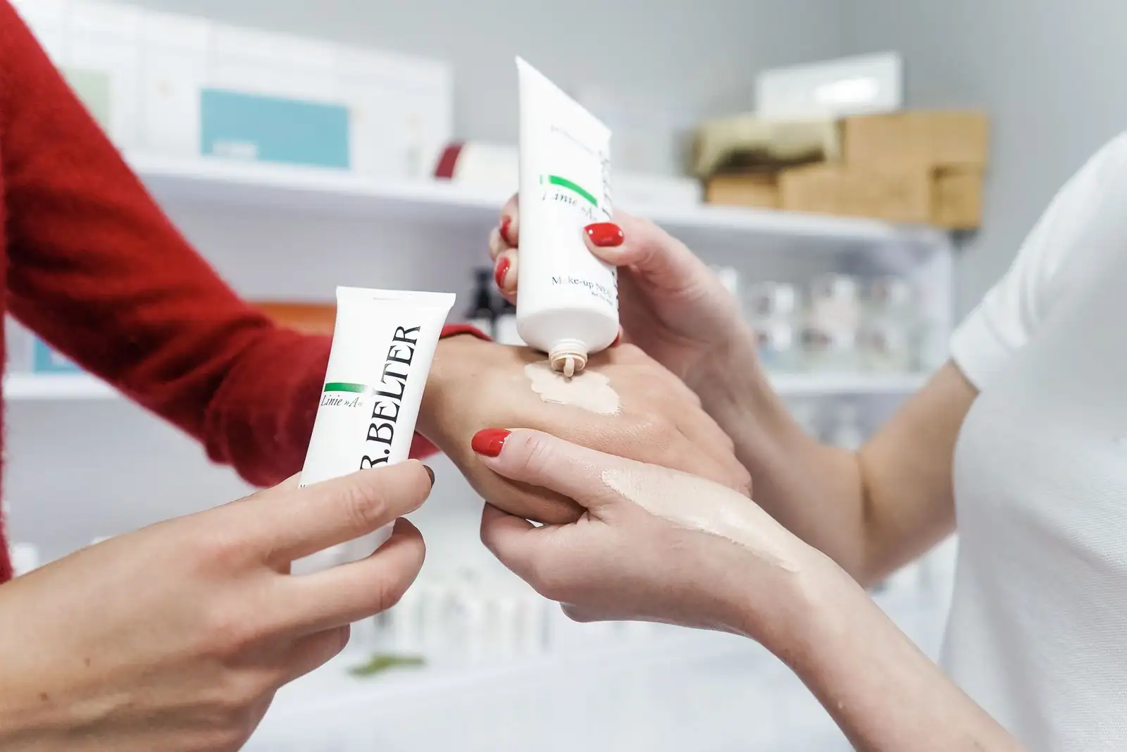 Essai d'une crème de soin sur la main dans une boutique de beauté, rayons de produits en arrière-plan.
