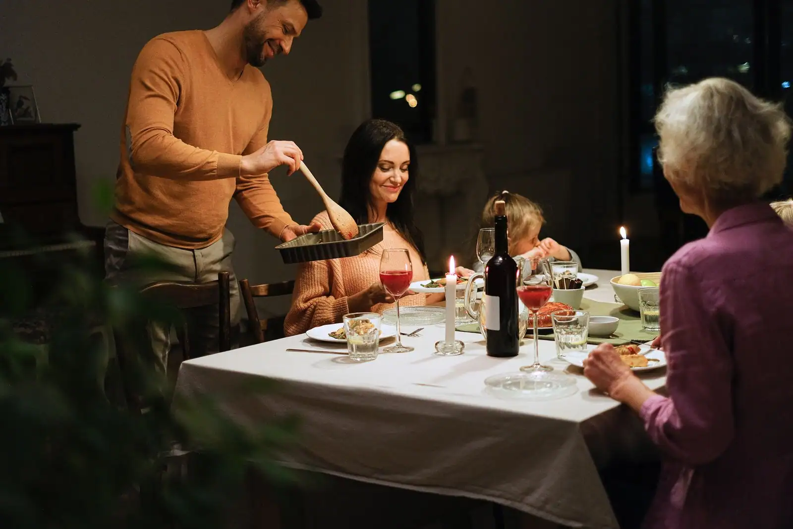 Famille de plusieurs générations partageant un repas du soir autour d'une table à la maison.
