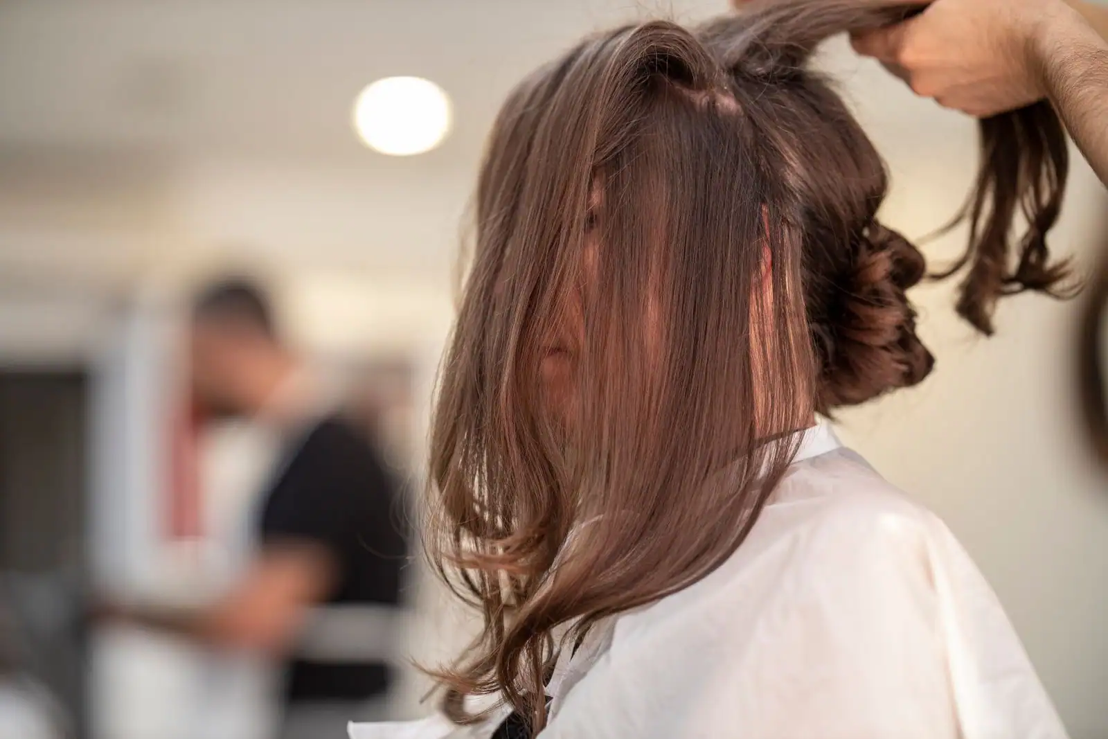 Femme aux cheveux châtain clair et reflets dorés, coiffure naturelle en lumière du jour