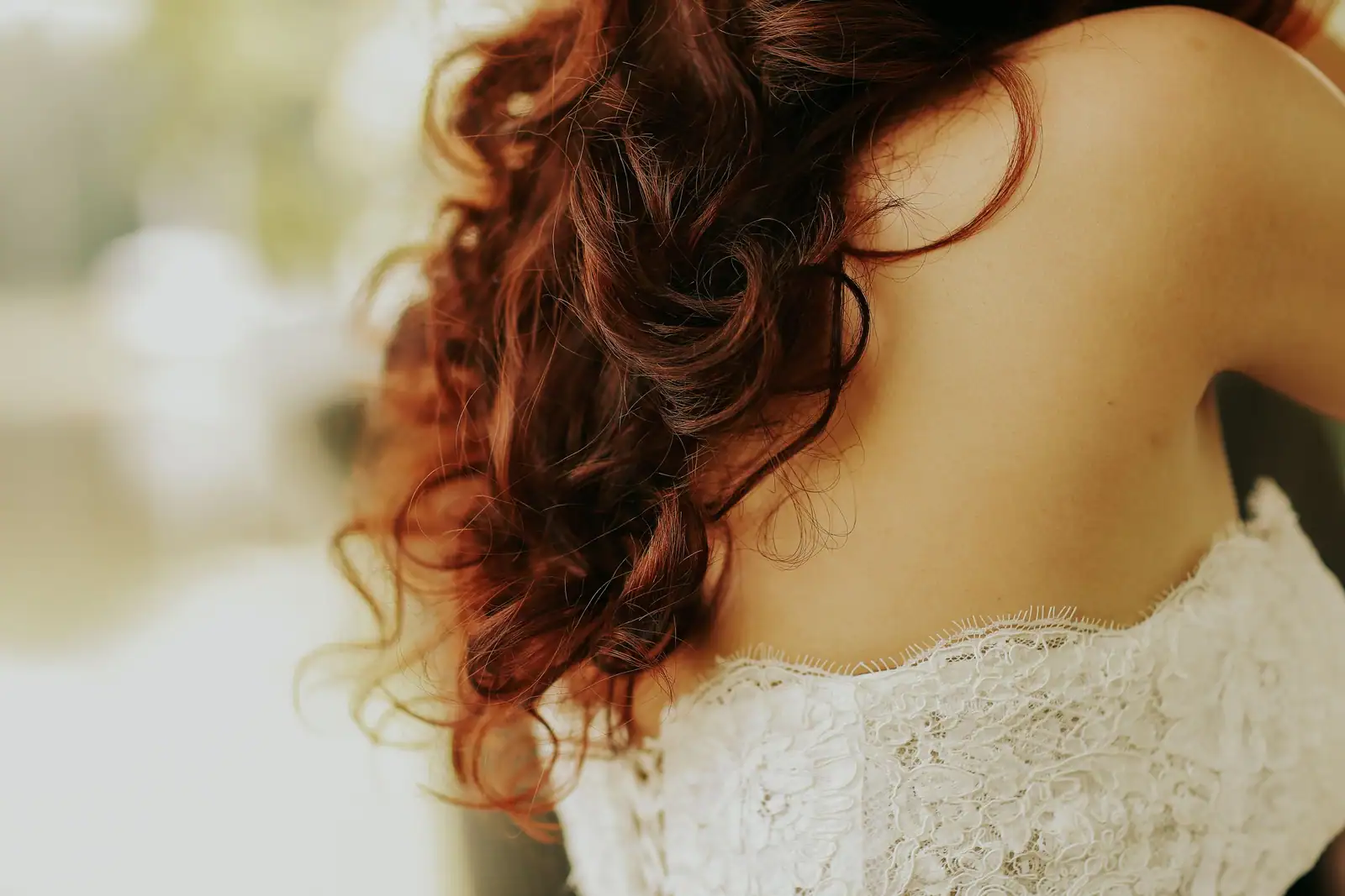 Chevelure rousse aux boucles souples et texturées, mouvement naturel en spirale sans lissage.