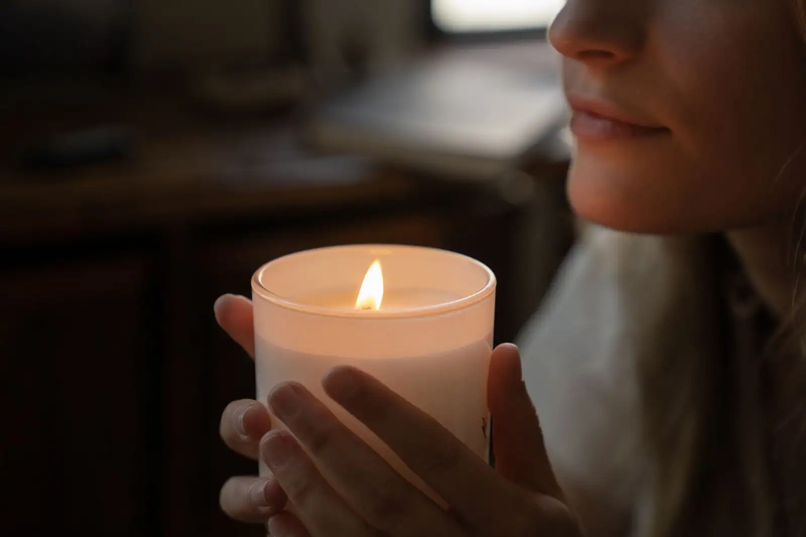 Femme assise en pratique de méditation silencieuse, à la lumière d'une bougie tôt le matin
